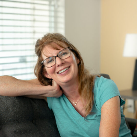 Beth Behrendt Smiling on sofa in living room